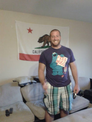Selim dans son appartement avec le drapeau de la Californie en toile de fond